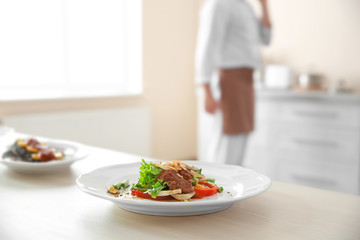 Plates with tasty dishes on kitchen table, closeup