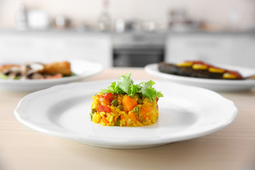 Tasty risotto on plate on kitchen table, closeup