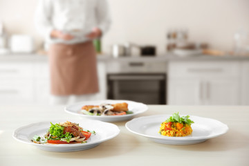 Plates with tasty dishes on kitchen table, closeup