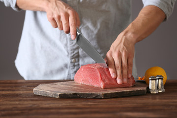Butcher cutting pork meat on kitchen