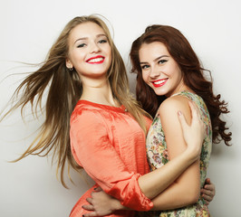 Two young girl friends standing together and having fun. 
