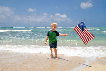 Little boy with an American flag on the beach