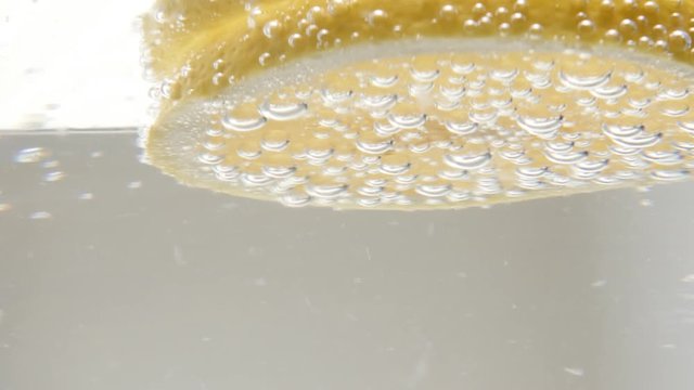 Carbonated water and ice cubes in the glass close-up 4K 2160p 30fps UltraHD footage - Lemon slice in cooled tonic 3840X2160 UHD video 