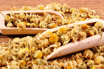 Dried chamomile on wooden table, alternative medicine