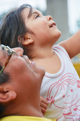 Happy latin dad and daughter looking up