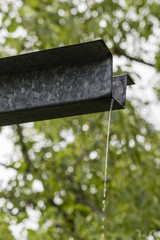 Trickle of rainwater flowing from the eaves.