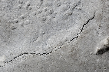 A crack in the concrete. The destruction of the concrete foundat