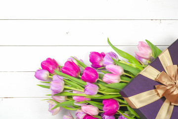 Bright, beautiful tulips on a wooden background. Top view. Copy space for text.