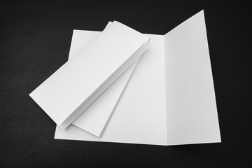 Trifold white template paper on black background .
