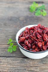 dried cranberries in a bowl on wooden table.
