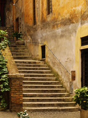 Fototapeta na wymiar Old and ramshackle stair on the narrow streets of Rome. Italy