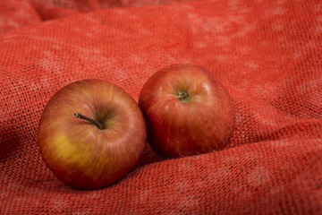 Apples on red burlap background