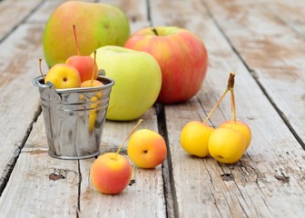 Variety of apples on a wooden table in small metal buckets.Selective focus