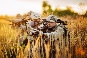 Rangers shooting with his weapon, rifle at sunset. War, army