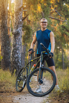 man cyclist rides forest paths