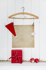 Hintergrund Weihnachten mit Papier Schild und Dekoration in weiß, braun und rot mit Geschenk als Weihnachtskarte oder Gutschein weihnachtlich mit Santa Claus.