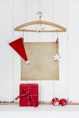 Hintergrund Weihnachten mit Papier Schild und Dekoration in weiß, braun und rot mit Geschenk als...
