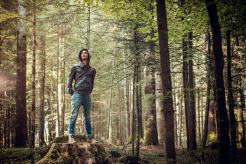 Naklejka premium Confident man standing in the forest