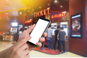 human hand hold and touch smartphone, tablet, cell phone with blank screen on blurry theater,
