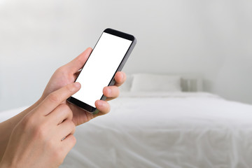 human hand hold and touch smartphone on  blurry bedroom background.
