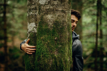 Young man hugging a tree