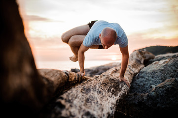 Handstand yoga pose by man on the beach near the ocean