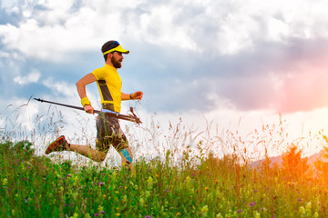 Man runner with rackets in hand down in the meadows