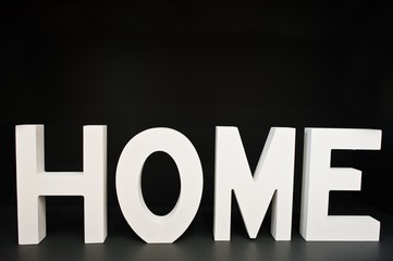 White wooden letters HOME at black background