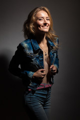 Beautiful blonde in denim dress on a black background