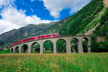 Swiss mountain train Bernina Express Cross the bridge in the cir - obrazy, fototapety, plakaty