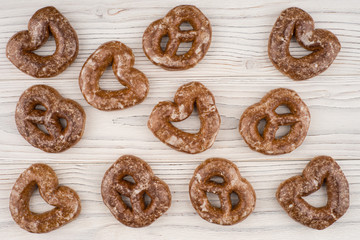 Gingerbread heart cookies on a wooden white background.