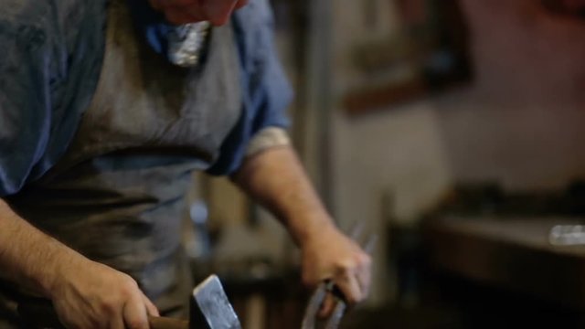 blacksmith forges the metal on the anvil