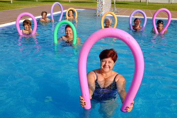 Group of seniors about to do exercise in pool.