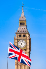 Fototapeta na wymiar UK Flag and London Sight / Blurry Union Jack flag in front of London Big Ben clock tower and blue sky