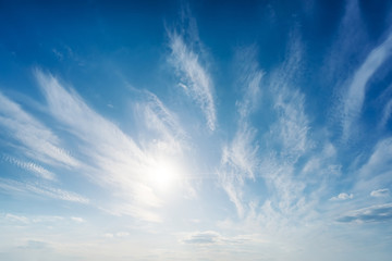 low sun and clouds in blue sky