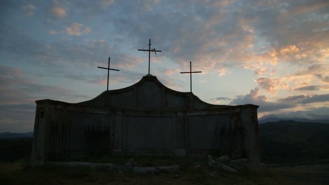 Tre Crocifissi in controluce su una collina al tramonto 