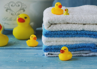 stack of colorful towels and bath duck on the table