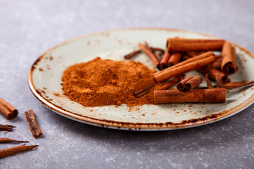 Cinnamon sticks and cinnamon powder on the plate.selective focus.