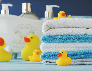 stack of colorful towels and bath duck on the table