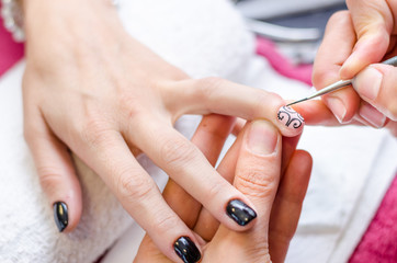 Woman applying black drawing nail polish