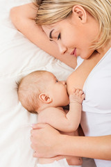 Young mother breastfeeds her baby. Breast-feeding.