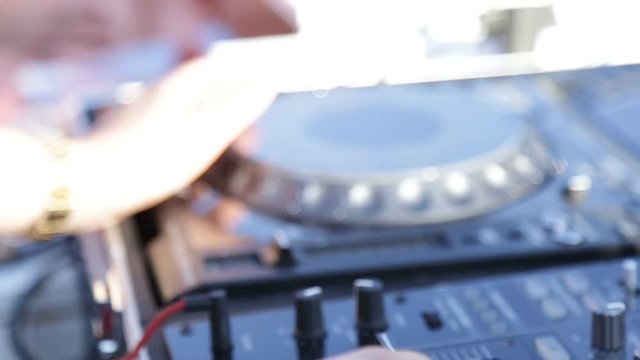Mani del deejay sul mixer al lavoro in una festa in discoteca all'aperto. 
