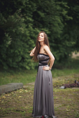 Fototapeta na wymiar Beauty Romantic Girl Outdoors. Teenage Model with Casual Dress in park. Blowing Long Hair.