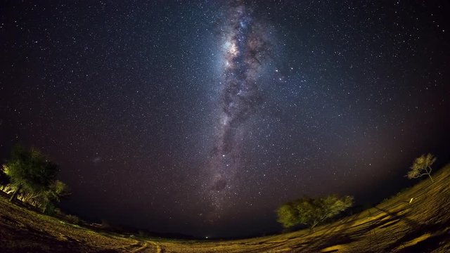 The apparent rotation of an outstandingly bright Milky Way and starry sky beyond mountain of the Namib desert, Namibia. Fish eye view. Time Lapse 4k video.