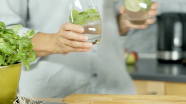 Woman bringing refreshing drinks and holding them on wooden board, dolly shot
