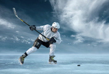 Ice hockey player in action outdoor around mountains