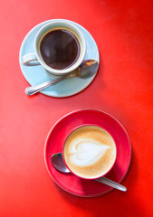 Two coffee cups on red background