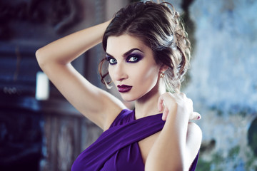 Beauty Brunette model woman in evening purple dress. Beautiful fashion luxury makeup and hairstyle.