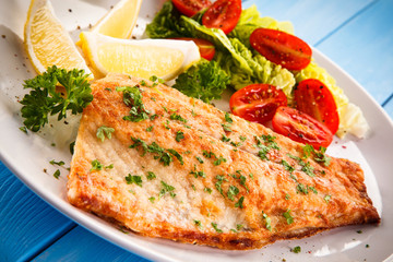 Fish dish - fried fish fillet baked potatoes and vegetables 