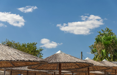 Fototapeta na wymiar Umbrella straw and blue cloudy sky background